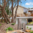 A house with a fence and trees in front of it