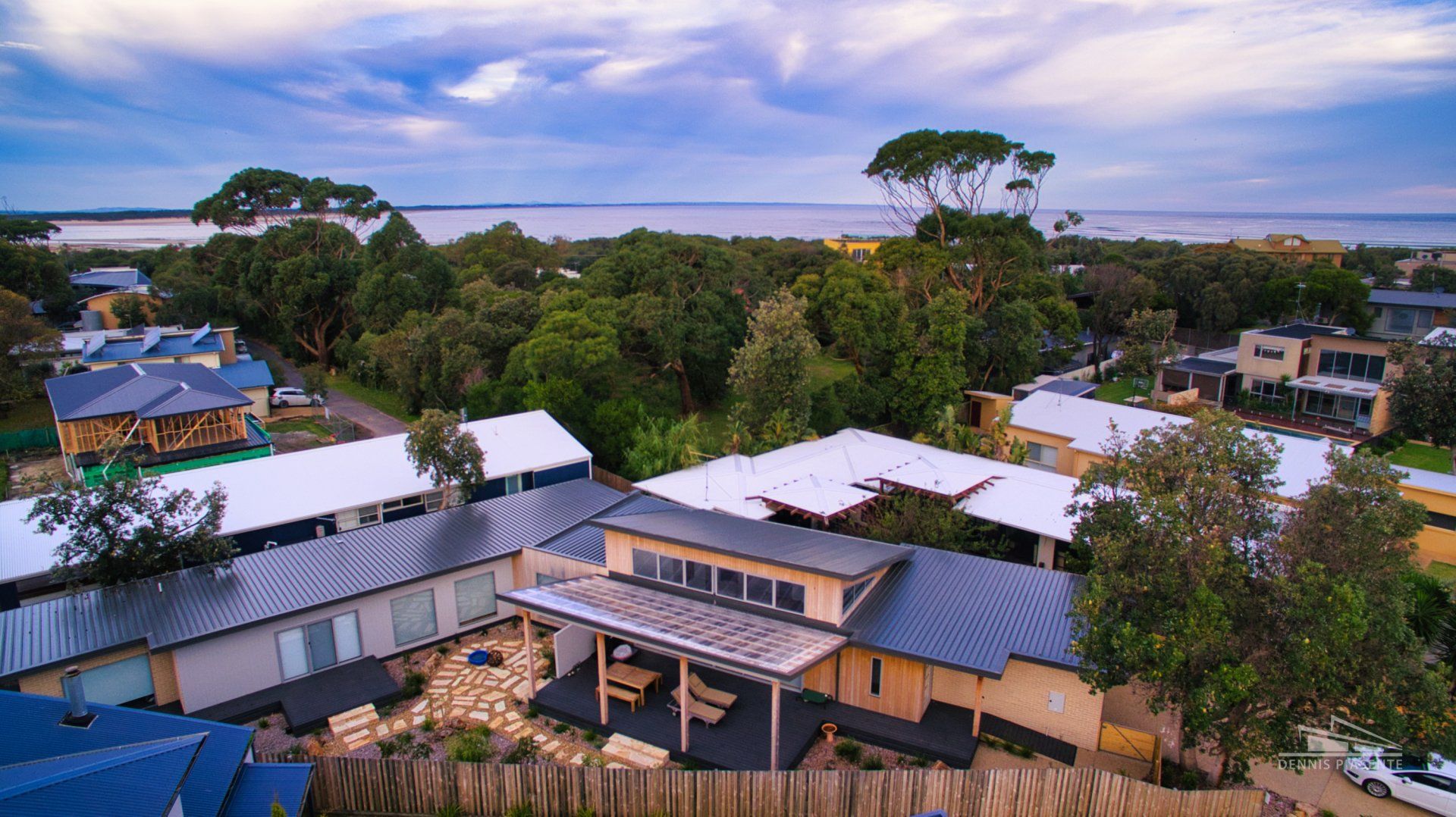 An aerial view of a residential area with a large body of water in the background.