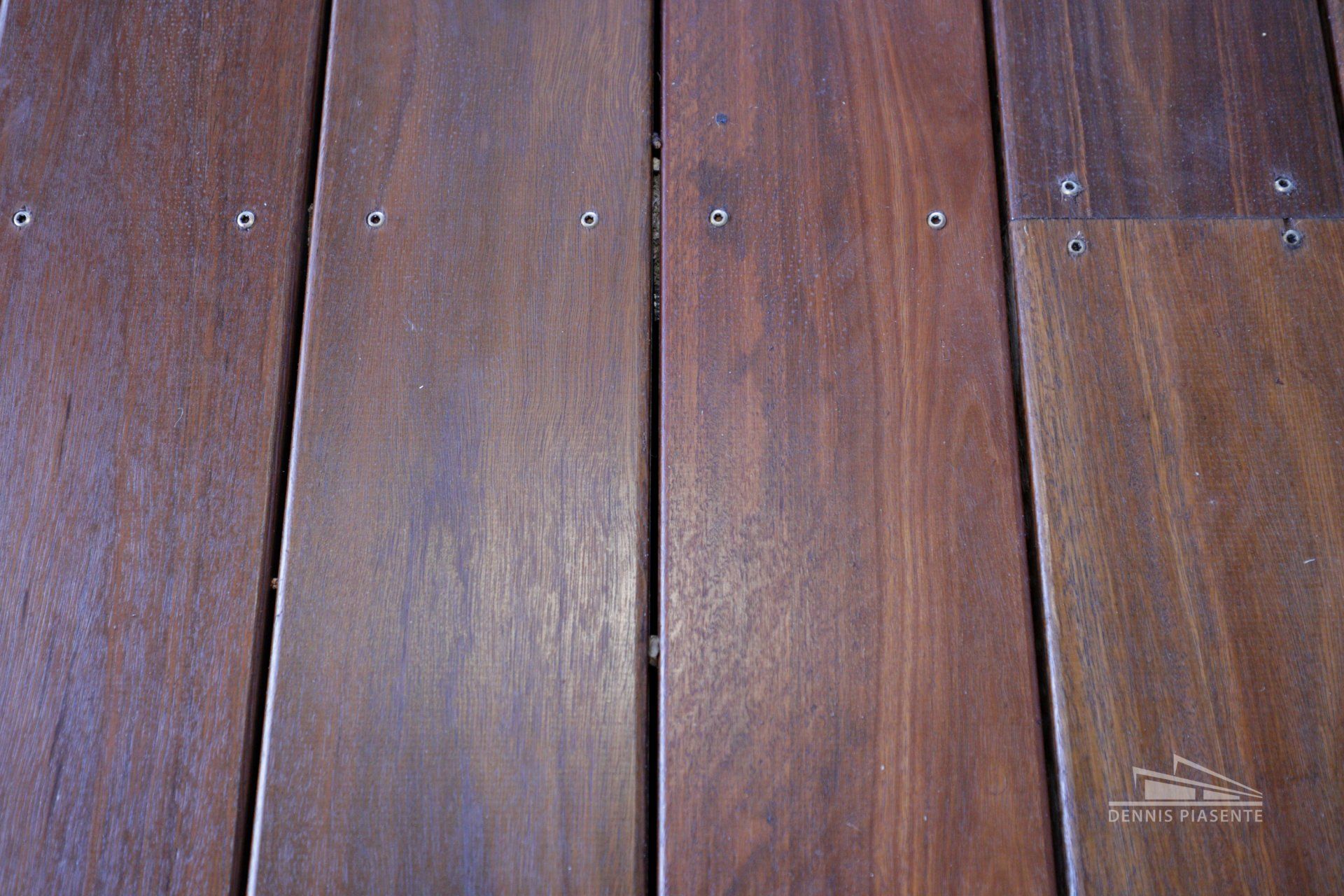 A close up of a wooden deck with screws on it.