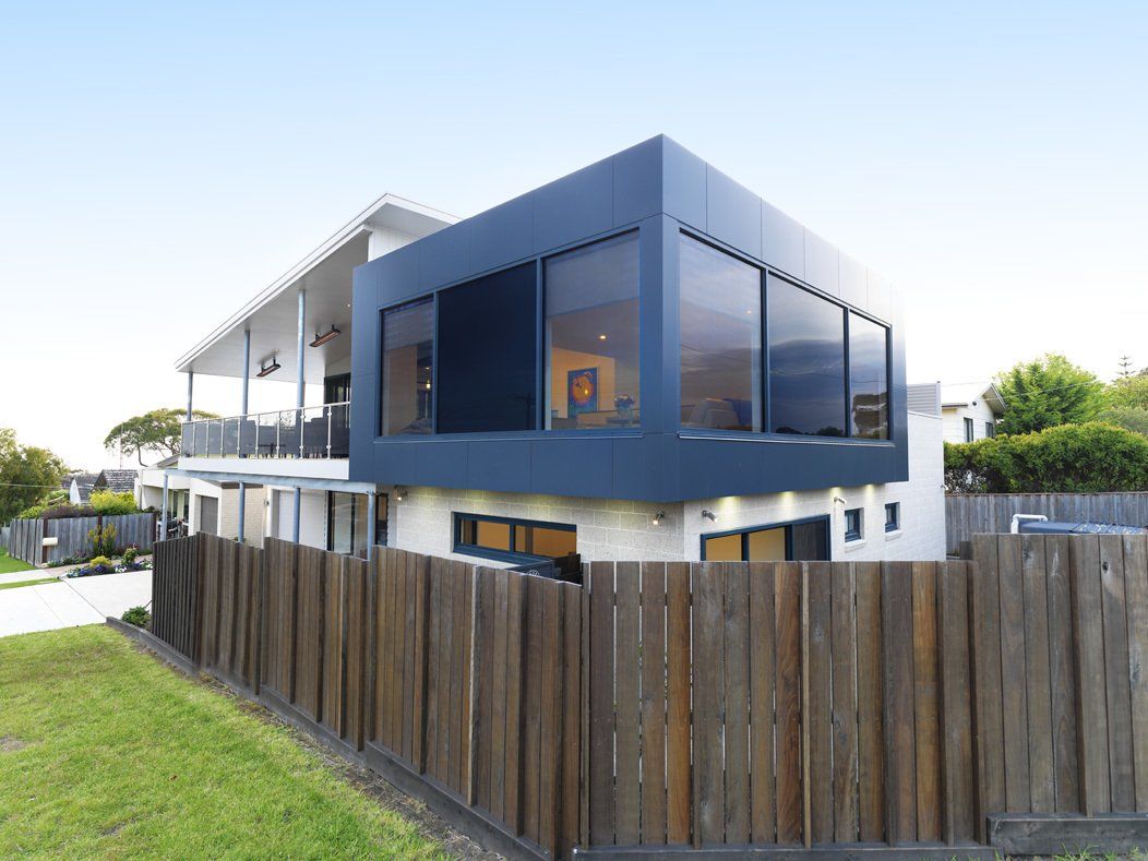 A modern house with a wooden fence around it.