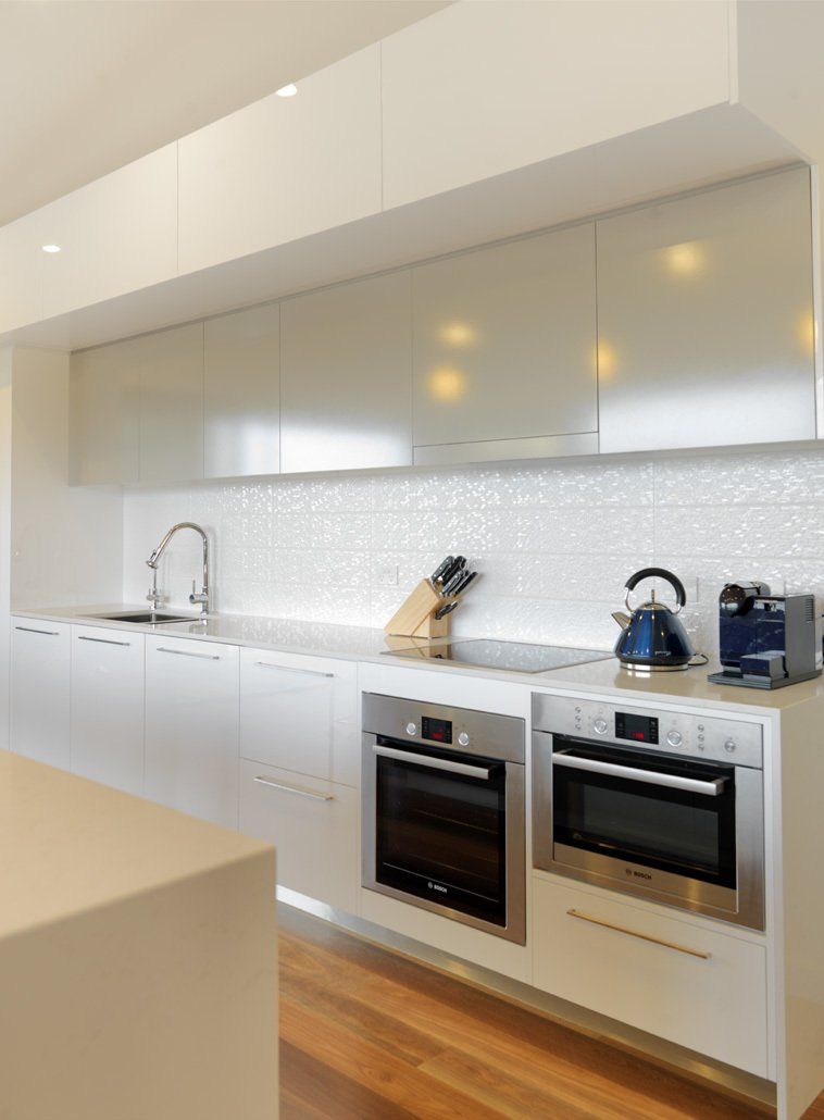 A kitchen with white cabinets and stainless steel appliances
