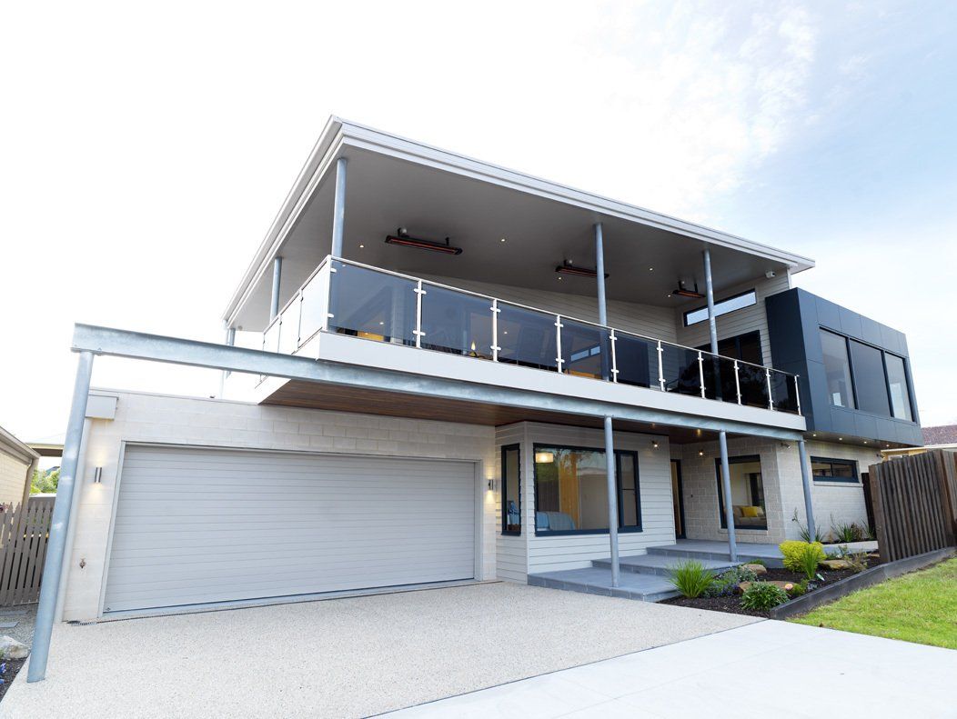 A large white house with a garage and a balcony.