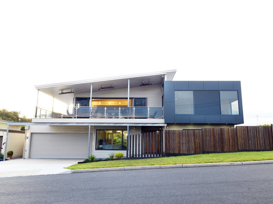 A large house with a wooden fence in front of it