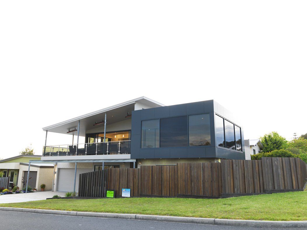 A large house with a wooden fence in front of it