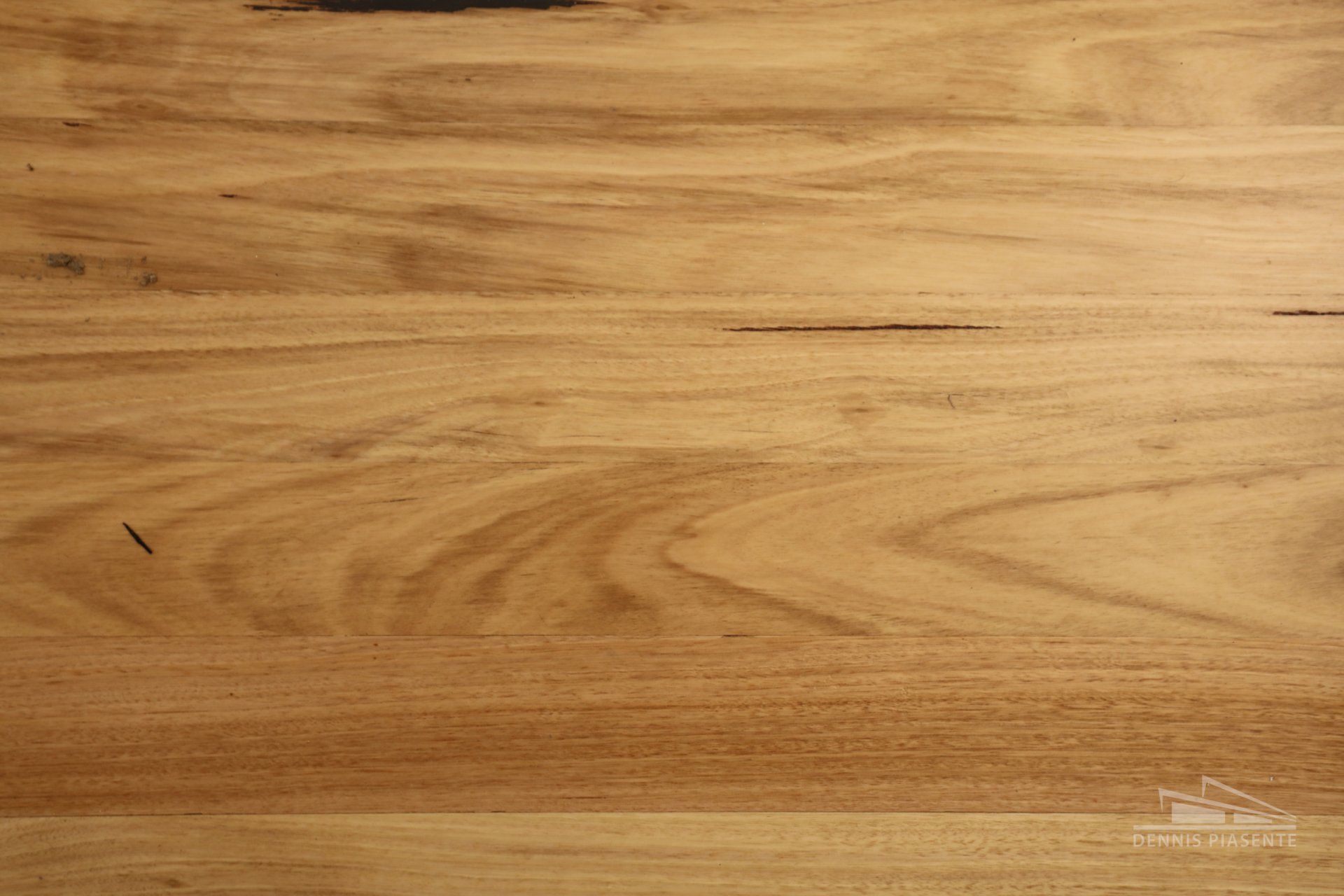 A close up of a wooden table top showing the grain of the wood.