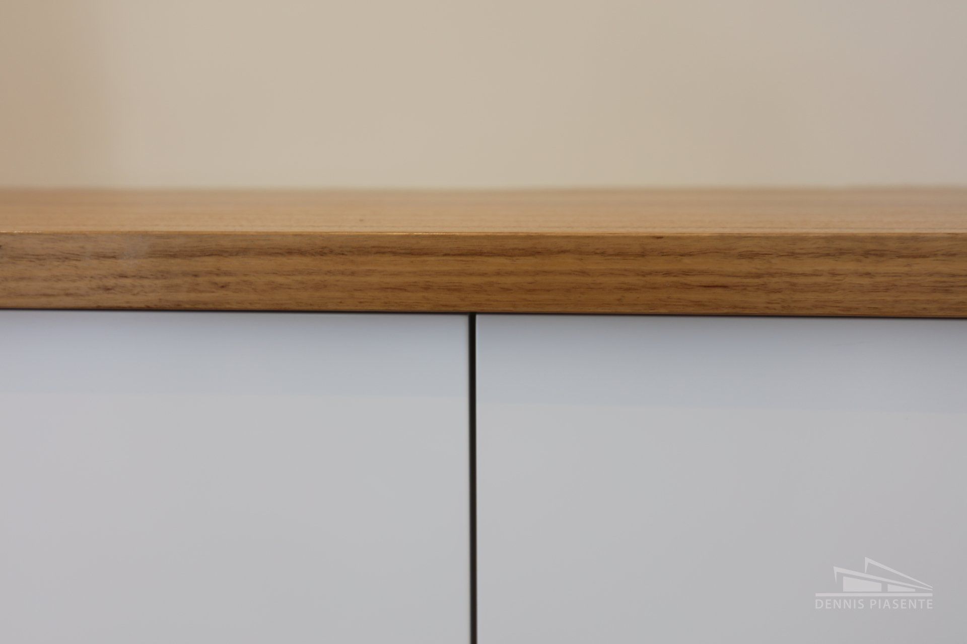 A close up of a white cabinet with a wooden top.