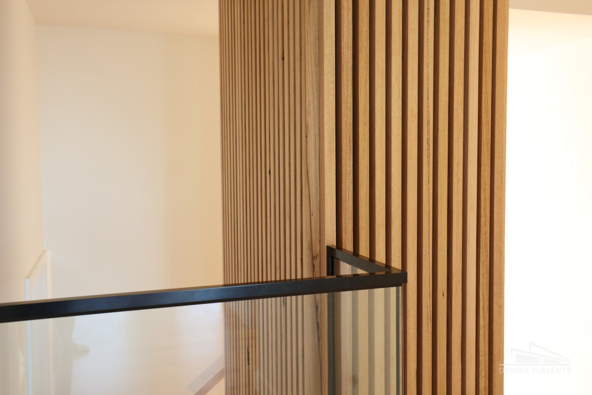 A room with a wooden wall and a glass railing.