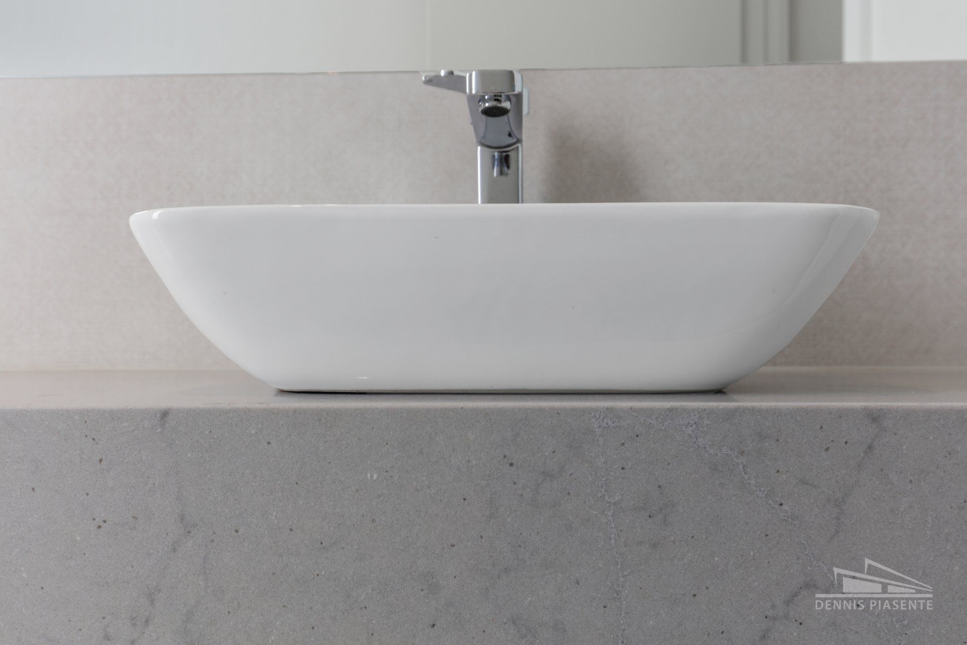 A bathroom sink is sitting on a counter next to a mirror.