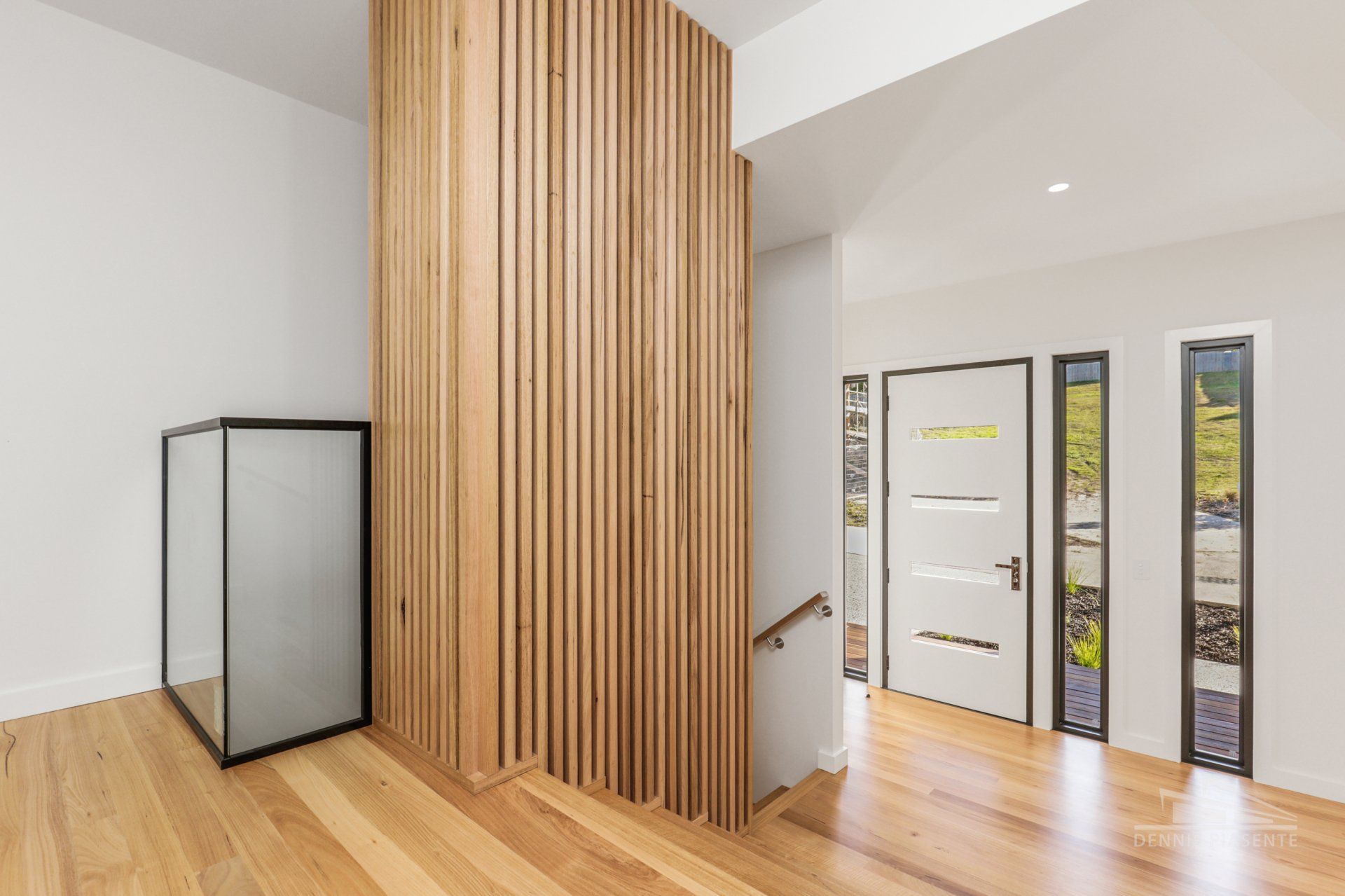 A hallway with hardwood floors and a wooden wall.
