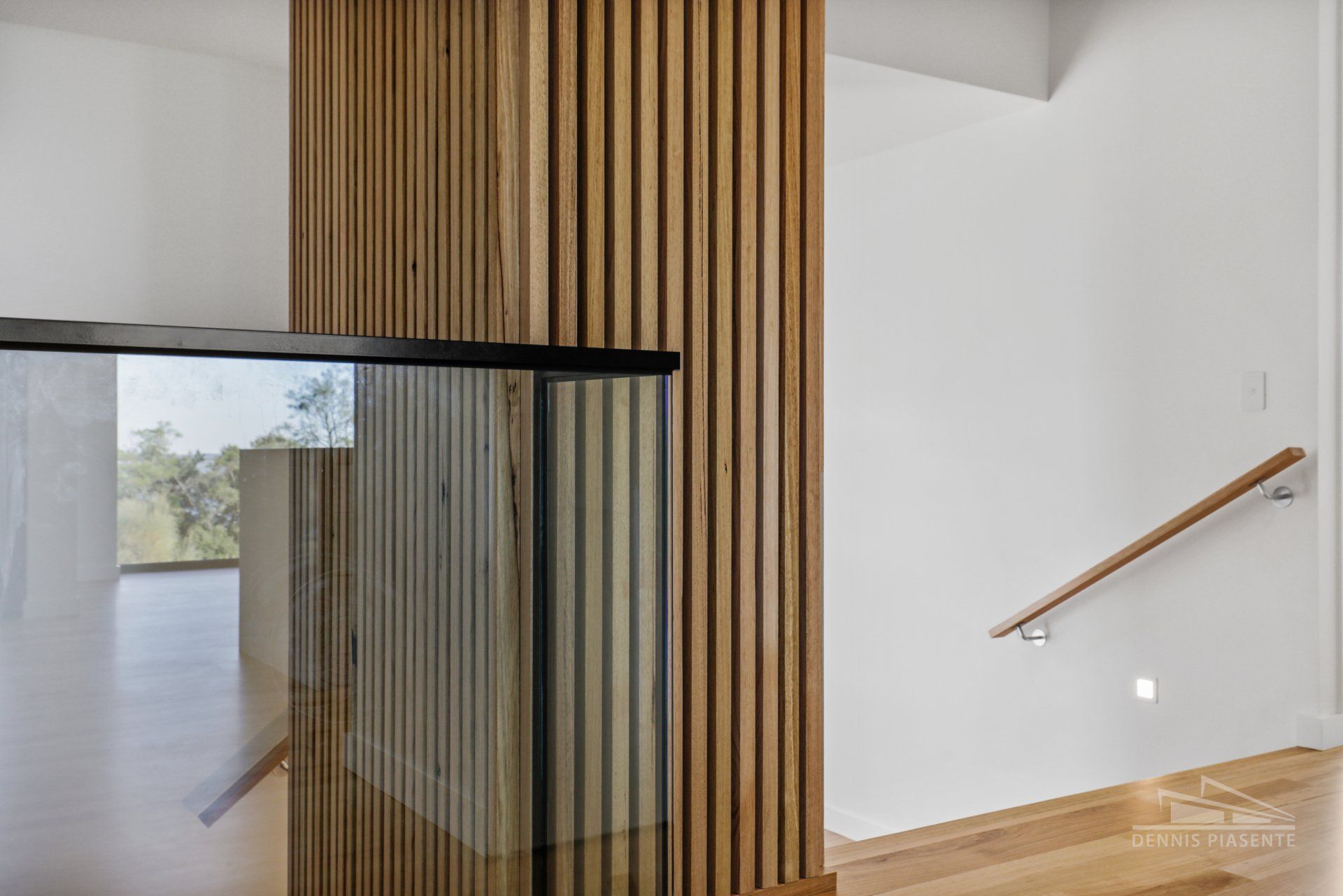 A staircase with a wooden railing and a glass railing in a house.