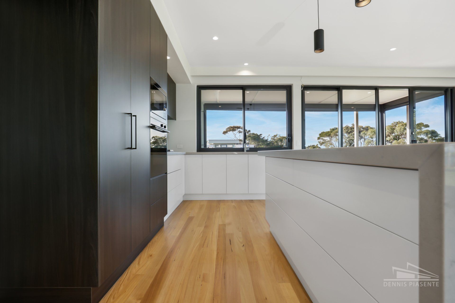 A kitchen with wooden floors and white cabinets