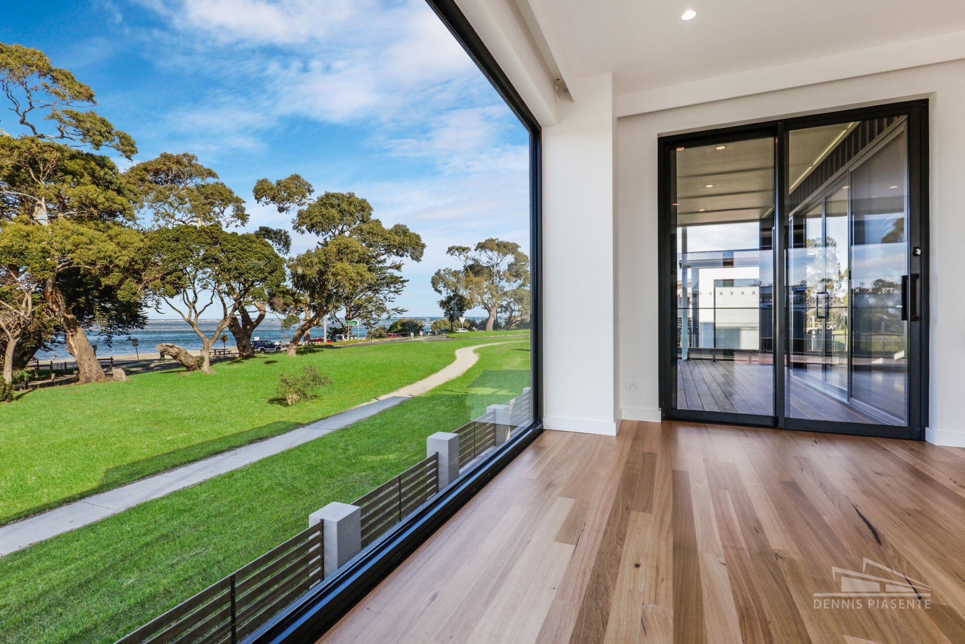 An empty room with a view of a grassy field and trees
