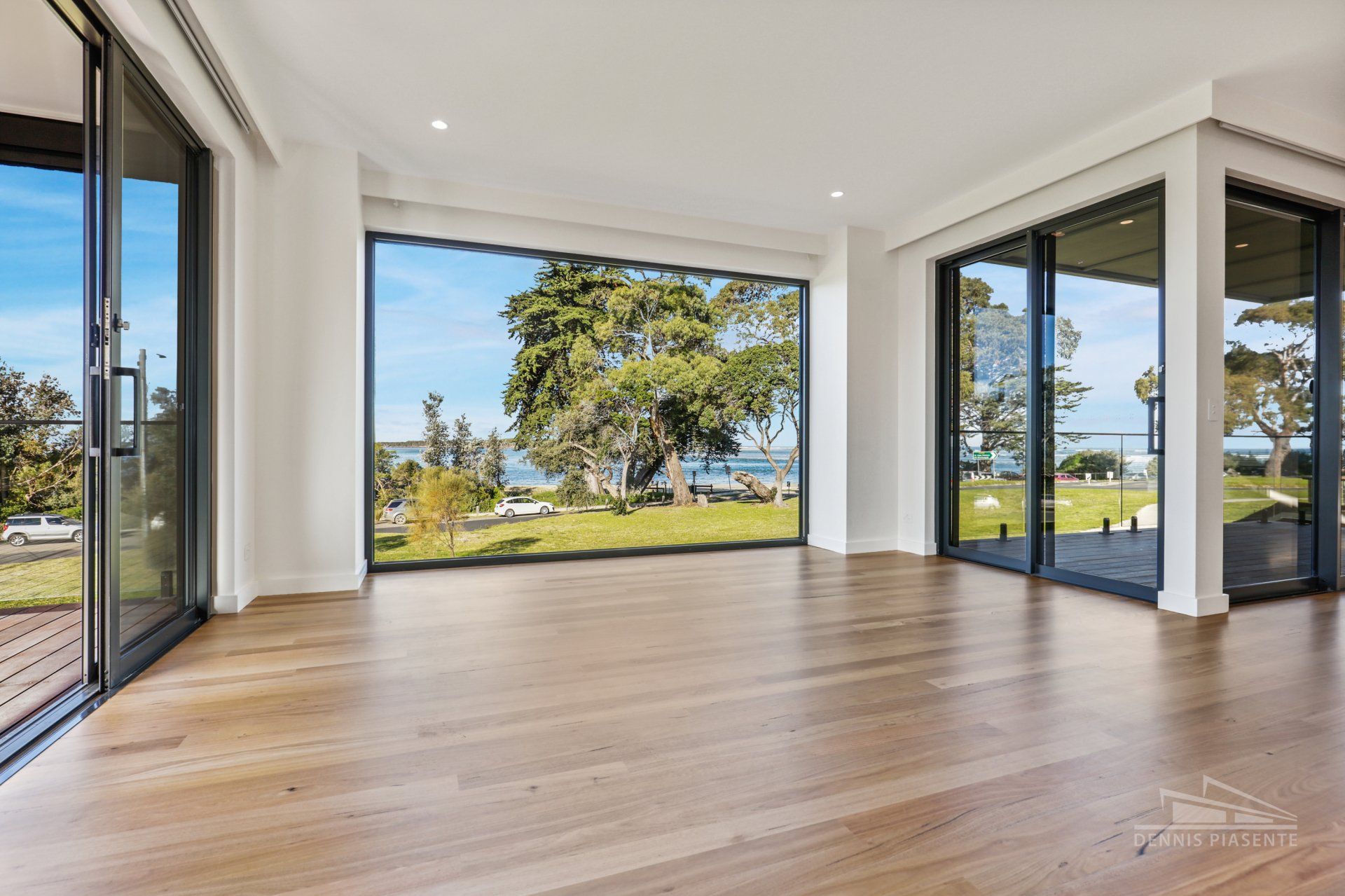 A large empty room with lots of windows and hardwood floors.