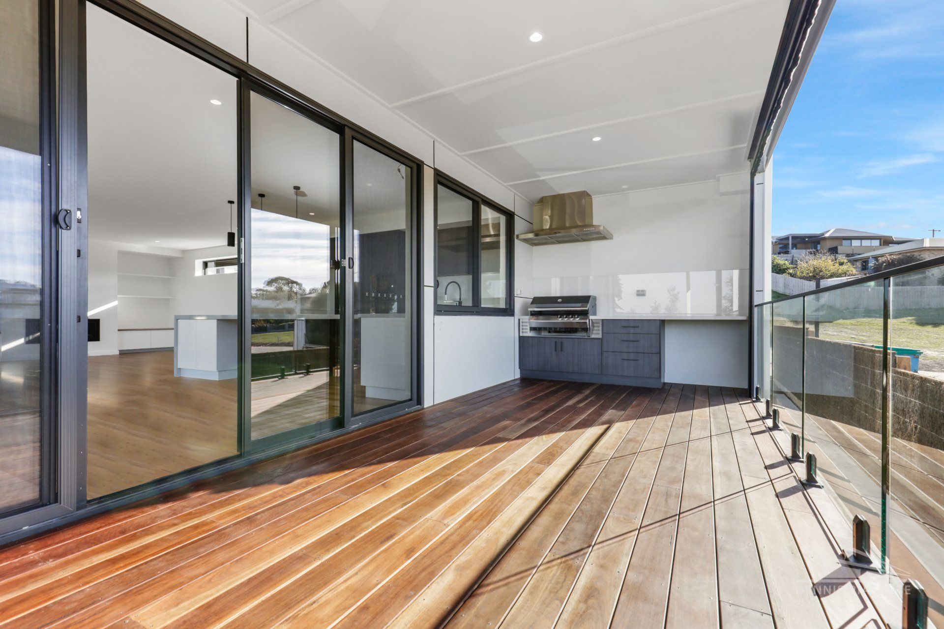 A large balcony with sliding glass doors and a wooden deck.