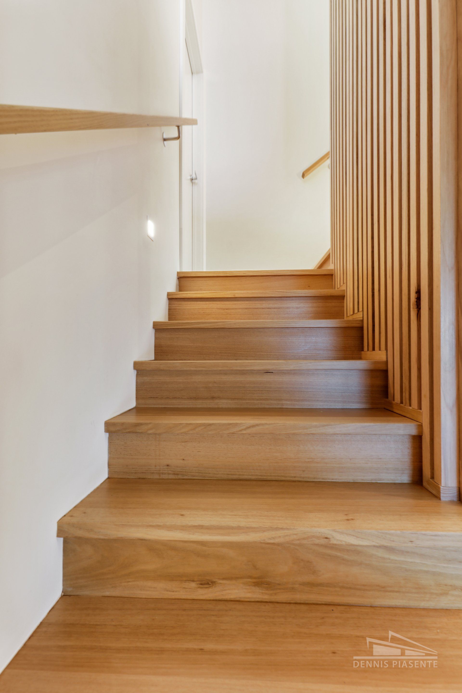 A wooden staircase leading up to the second floor of a house.