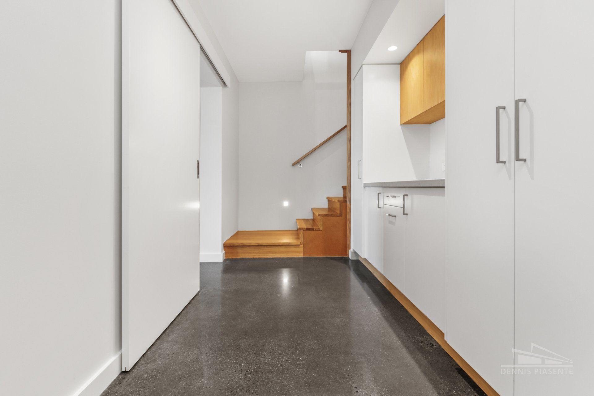 A hallway with stairs and cabinets in a house