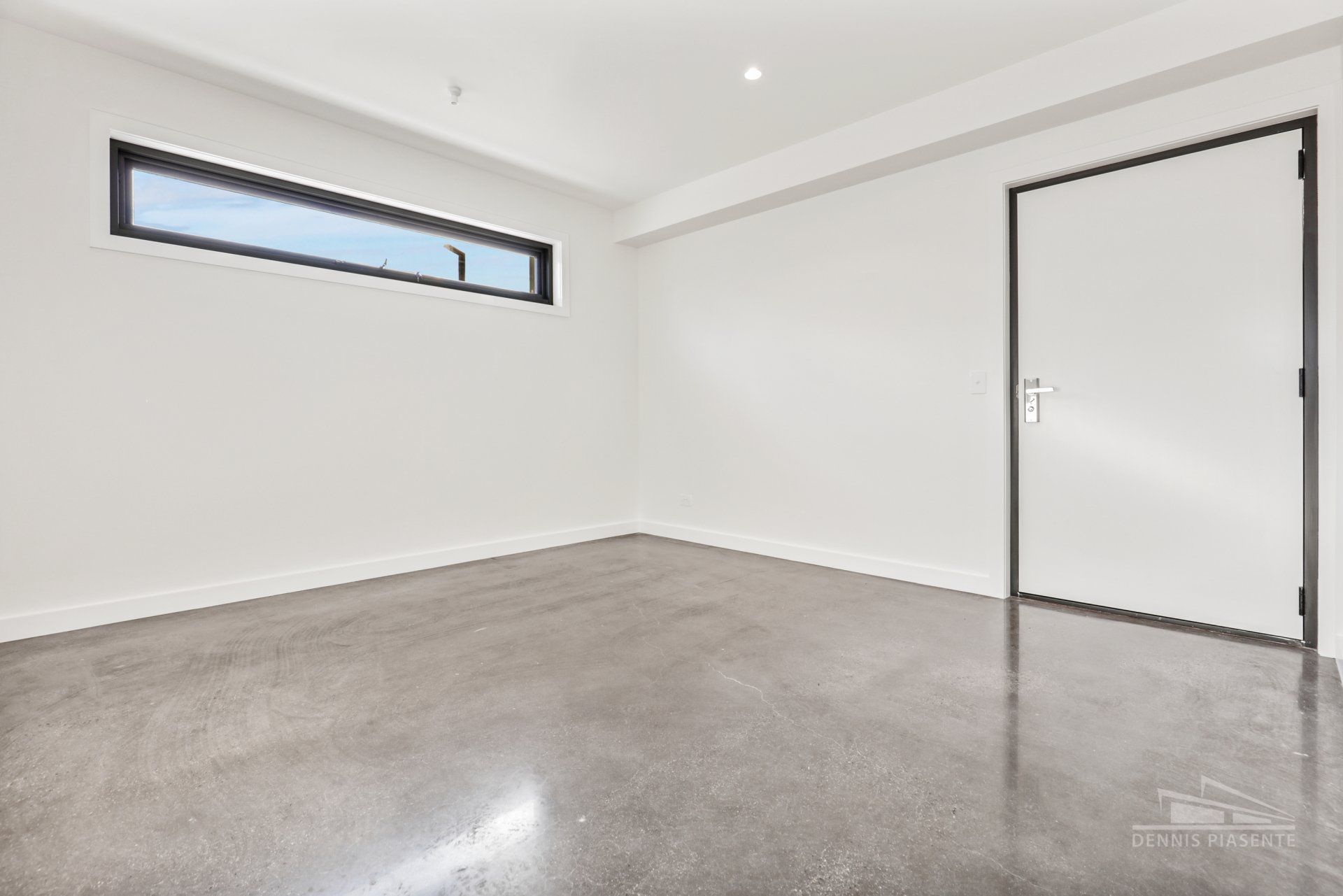 An empty room with a large window and a door.
