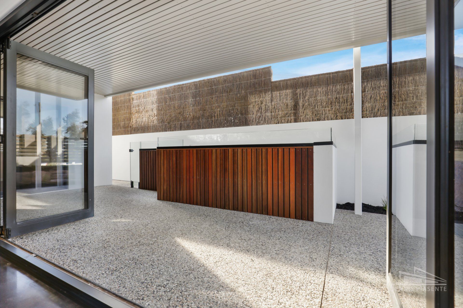A large sliding glass door leading to a patio with a wooden table.