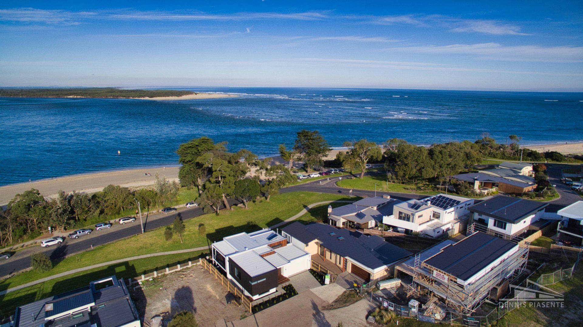 An aerial view of a residential area next to the ocean.
