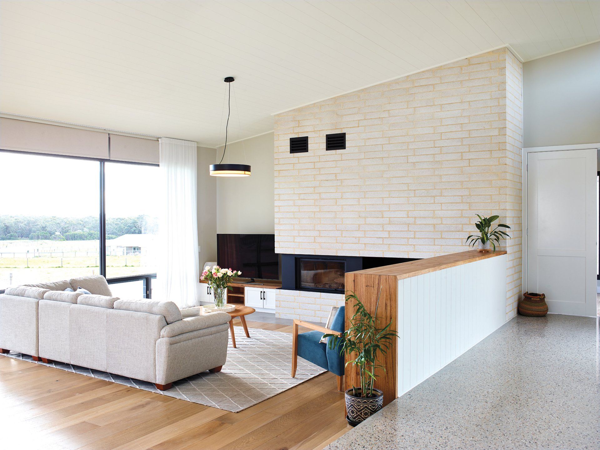 A living room with a couch , chair , table and fireplace.