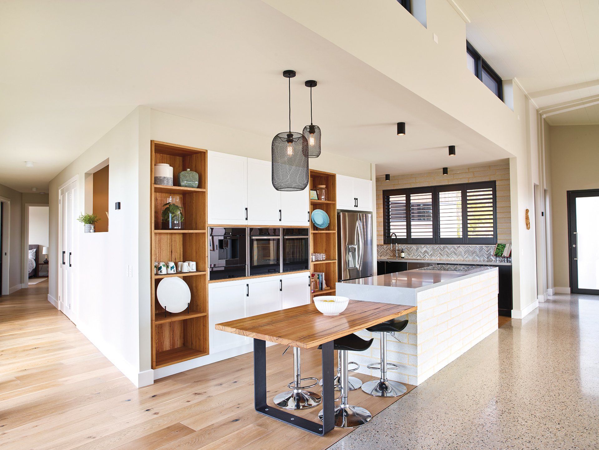 A kitchen with a table and stools in it