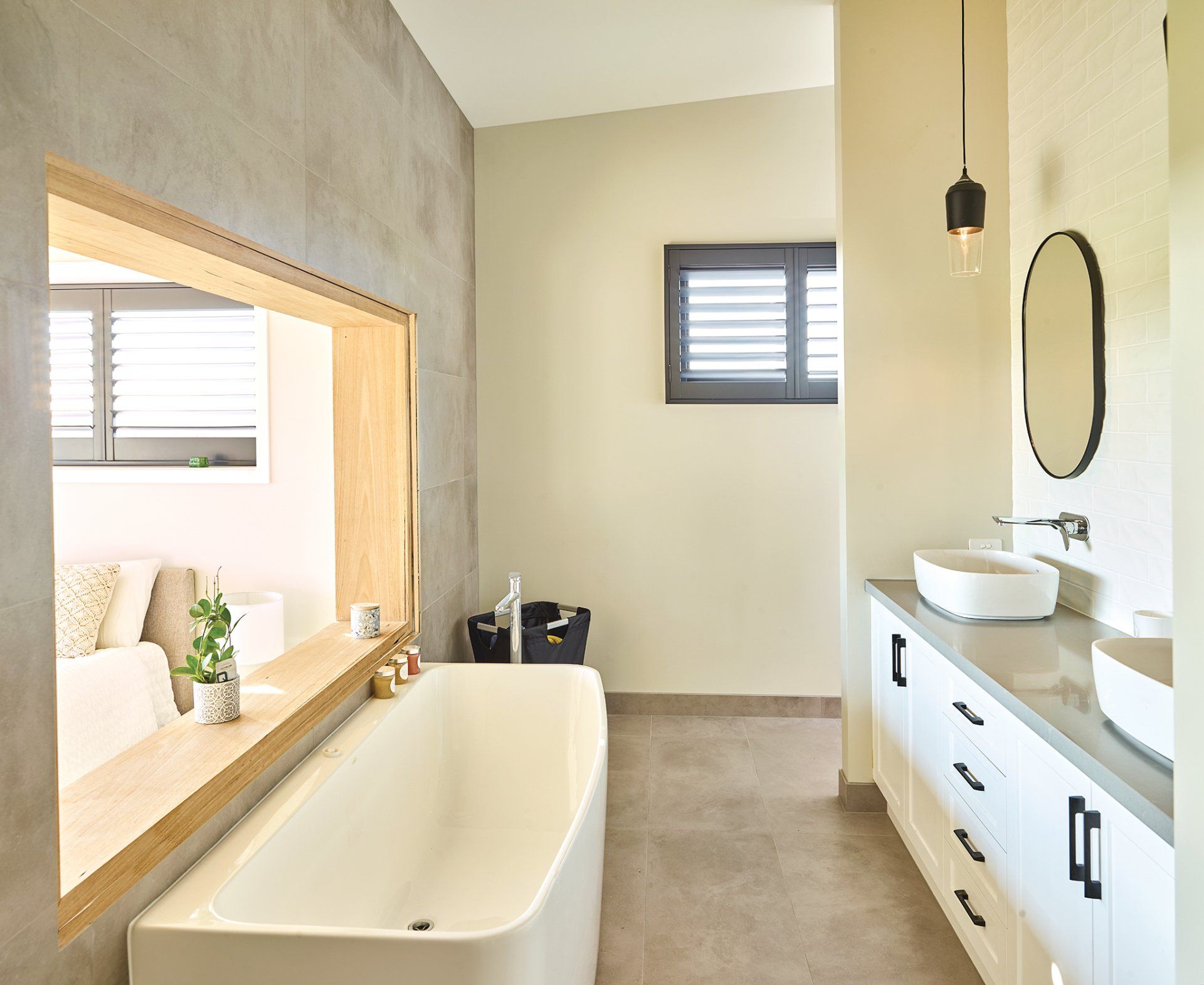 A bathroom with a bathtub , sinks , and a window.