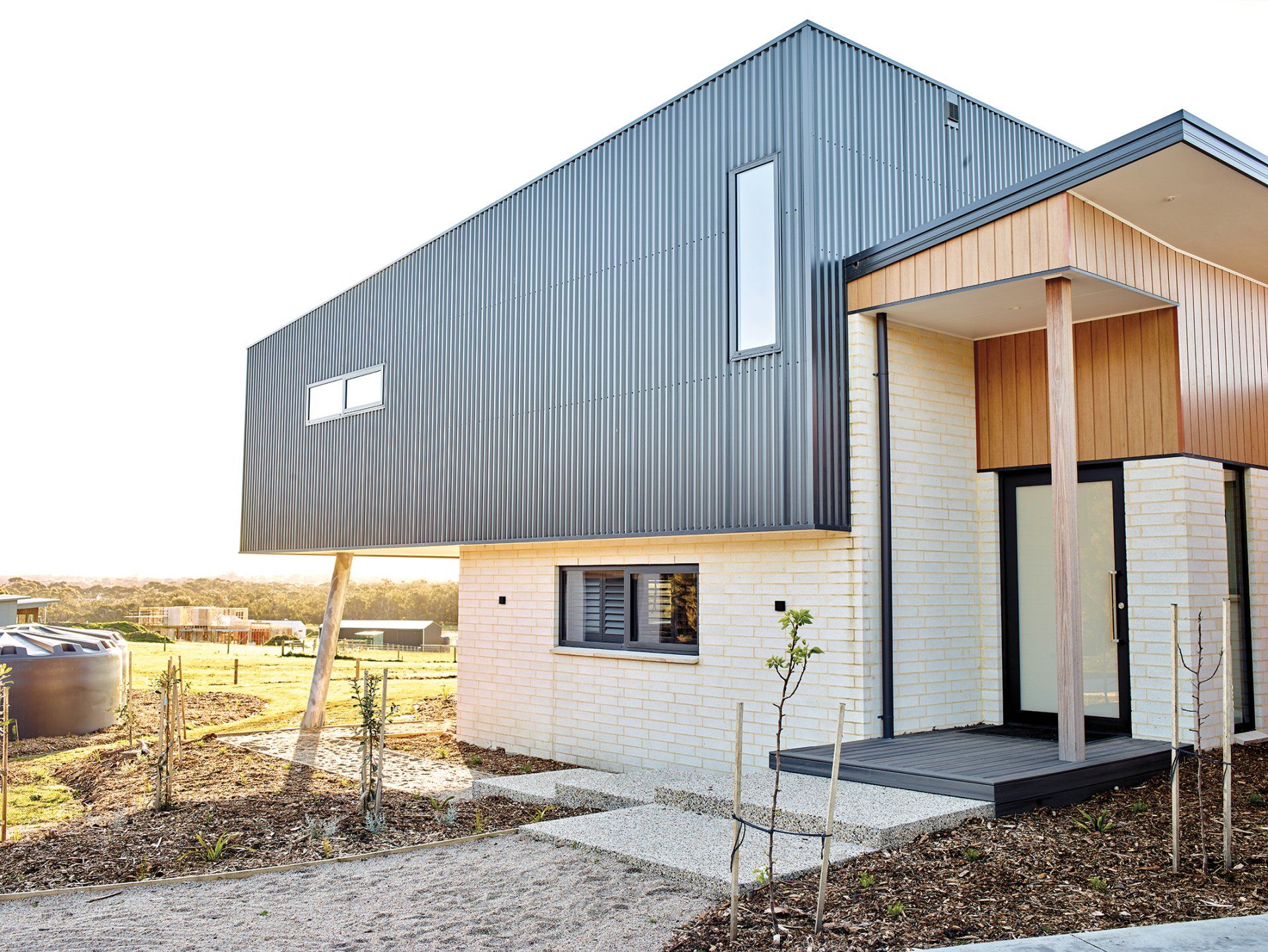 A modern house with a gray and white facade and a porch.