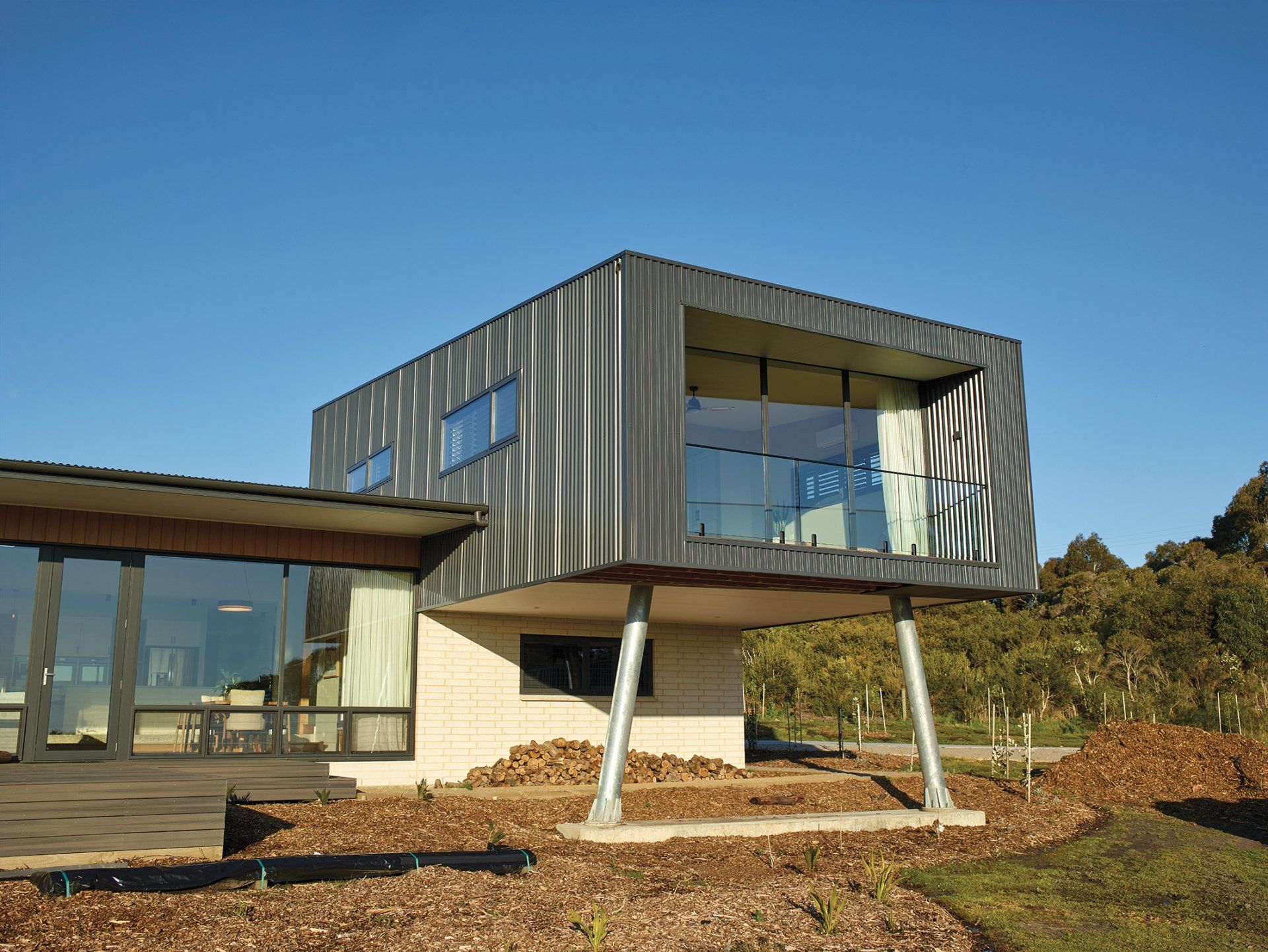 A modern house with a lot of windows and a balcony.