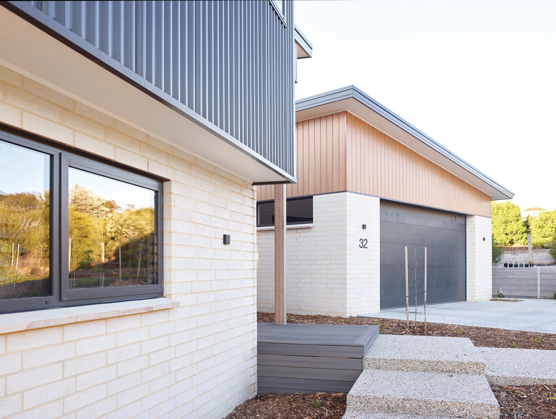 A white brick house with a black garage door