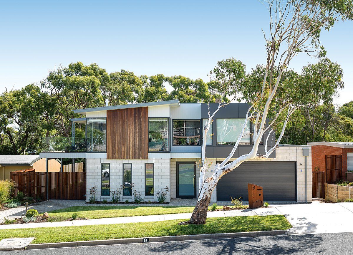 A large house with a lot of windows and a tree in front of it.