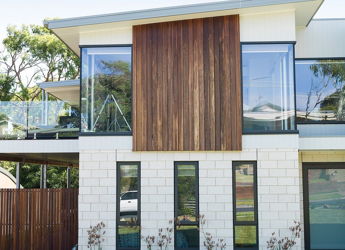 A modern house with a wooden siding and lots of windows