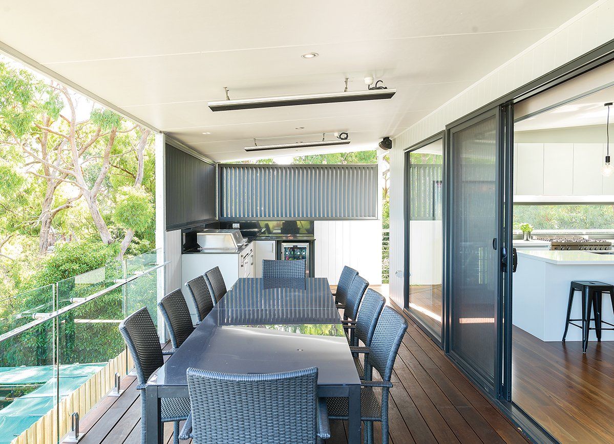 There is a large table and chairs on the balcony.