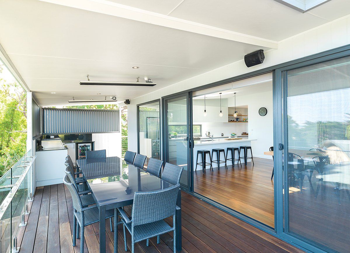 There is a large table and chairs on the balcony.