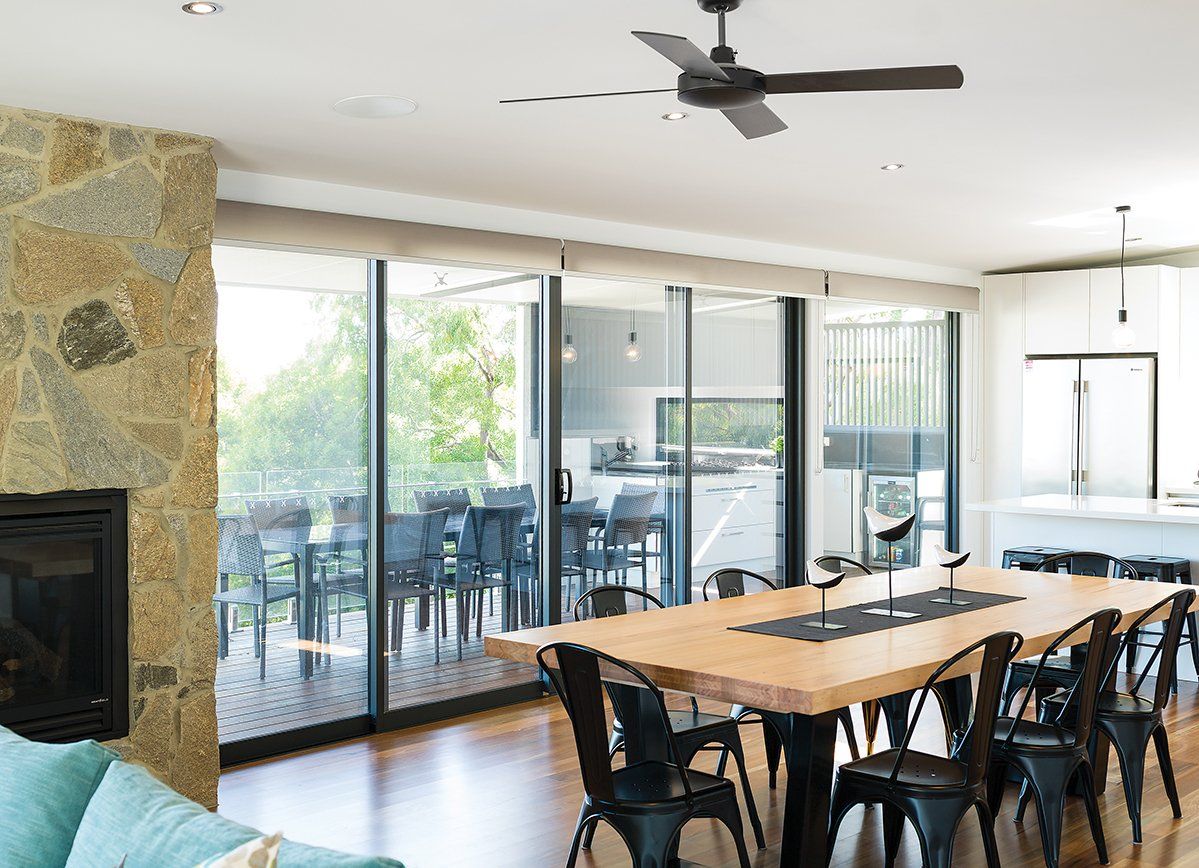 A living room with a table and chairs and a ceiling fan.