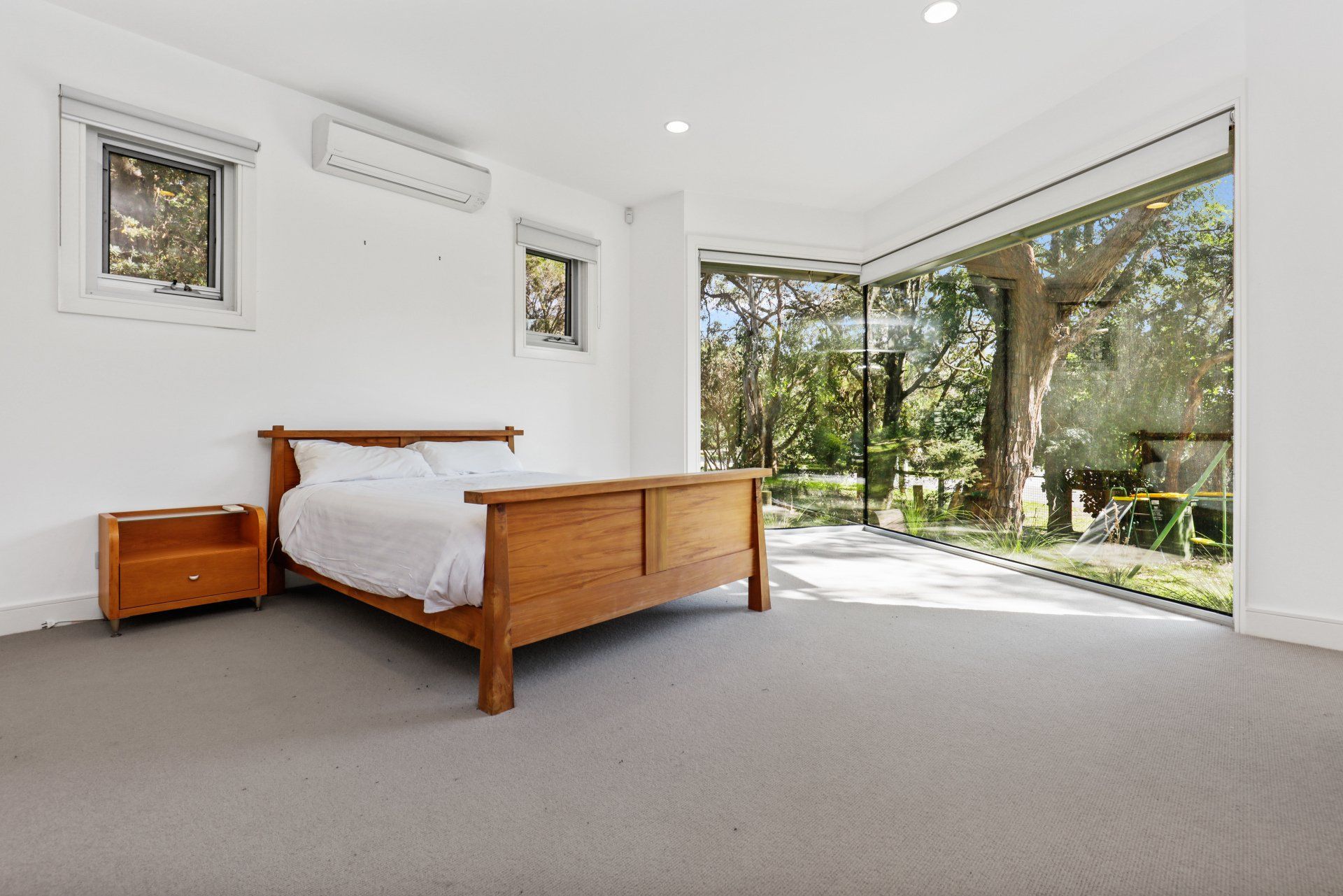 A bedroom with a large bed and a large window.