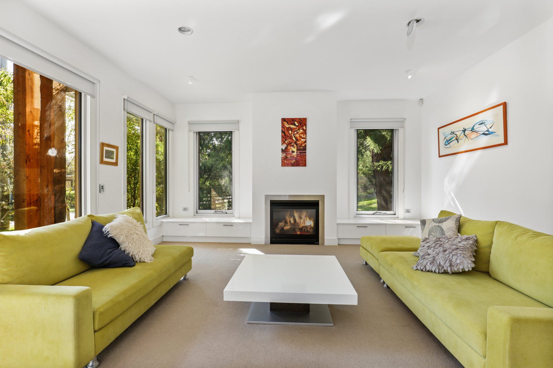 A living room with two yellow couches and a fireplace