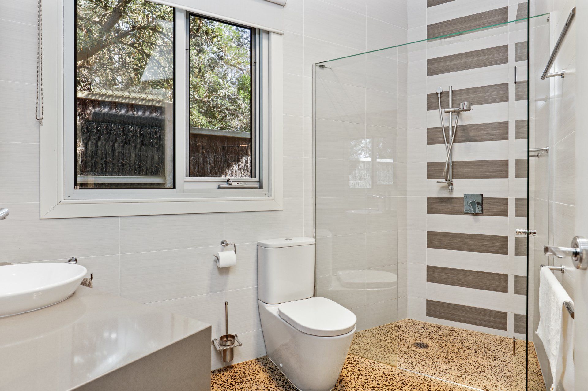 A bathroom with a toilet , sink , and walk in shower.