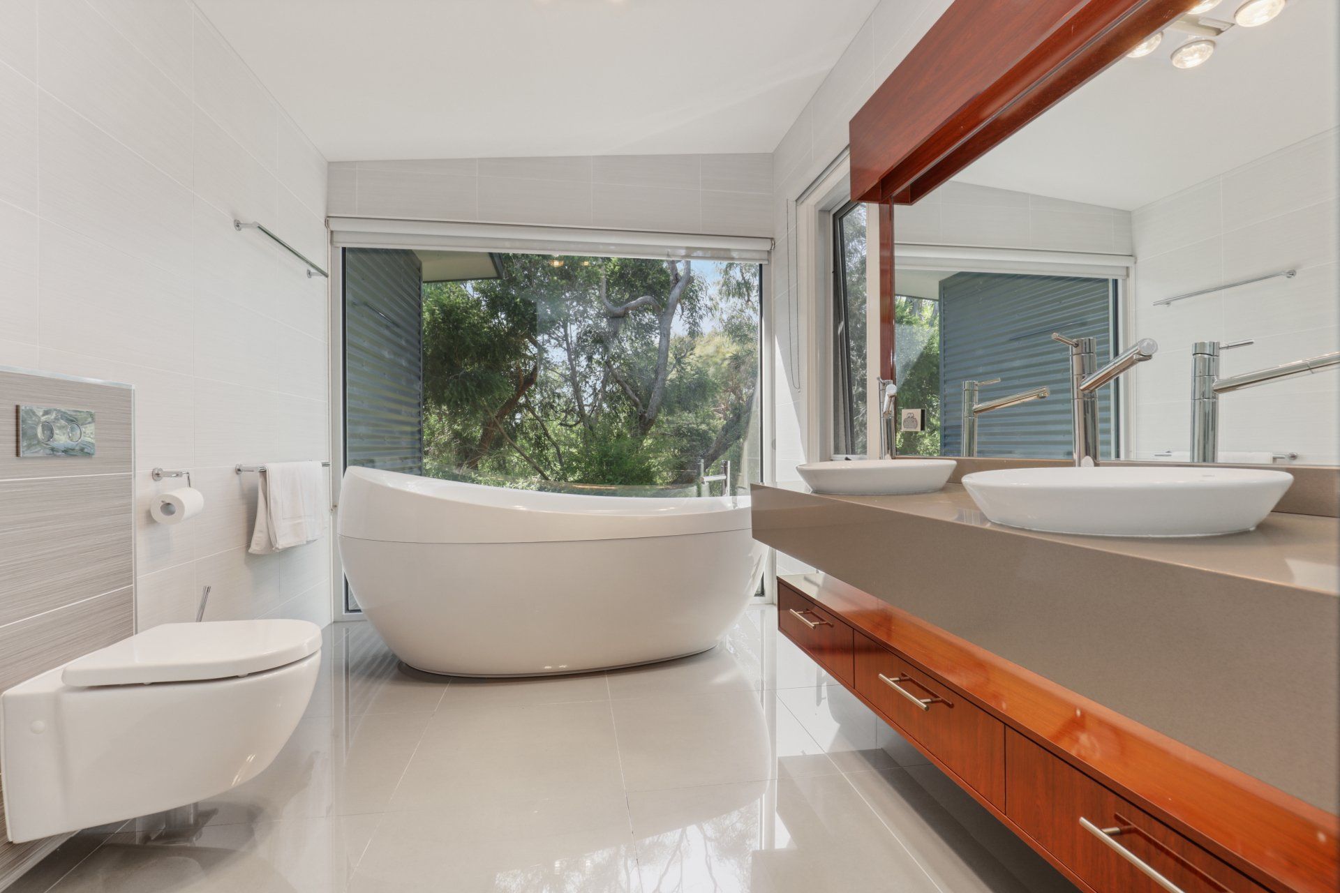 A bathroom with a tub , toilet , sink and mirror