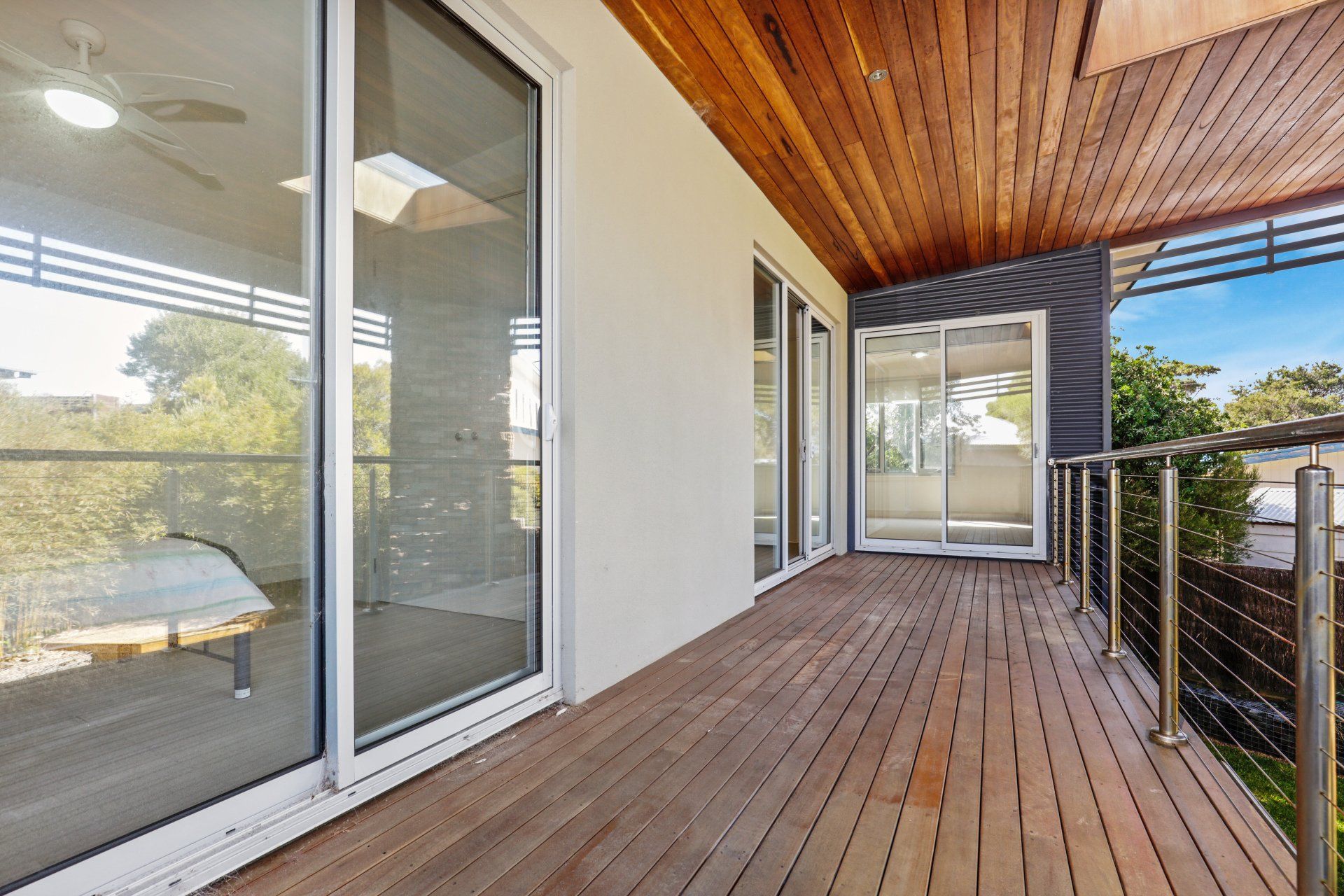 A large deck with sliding glass doors and a wooden ceiling