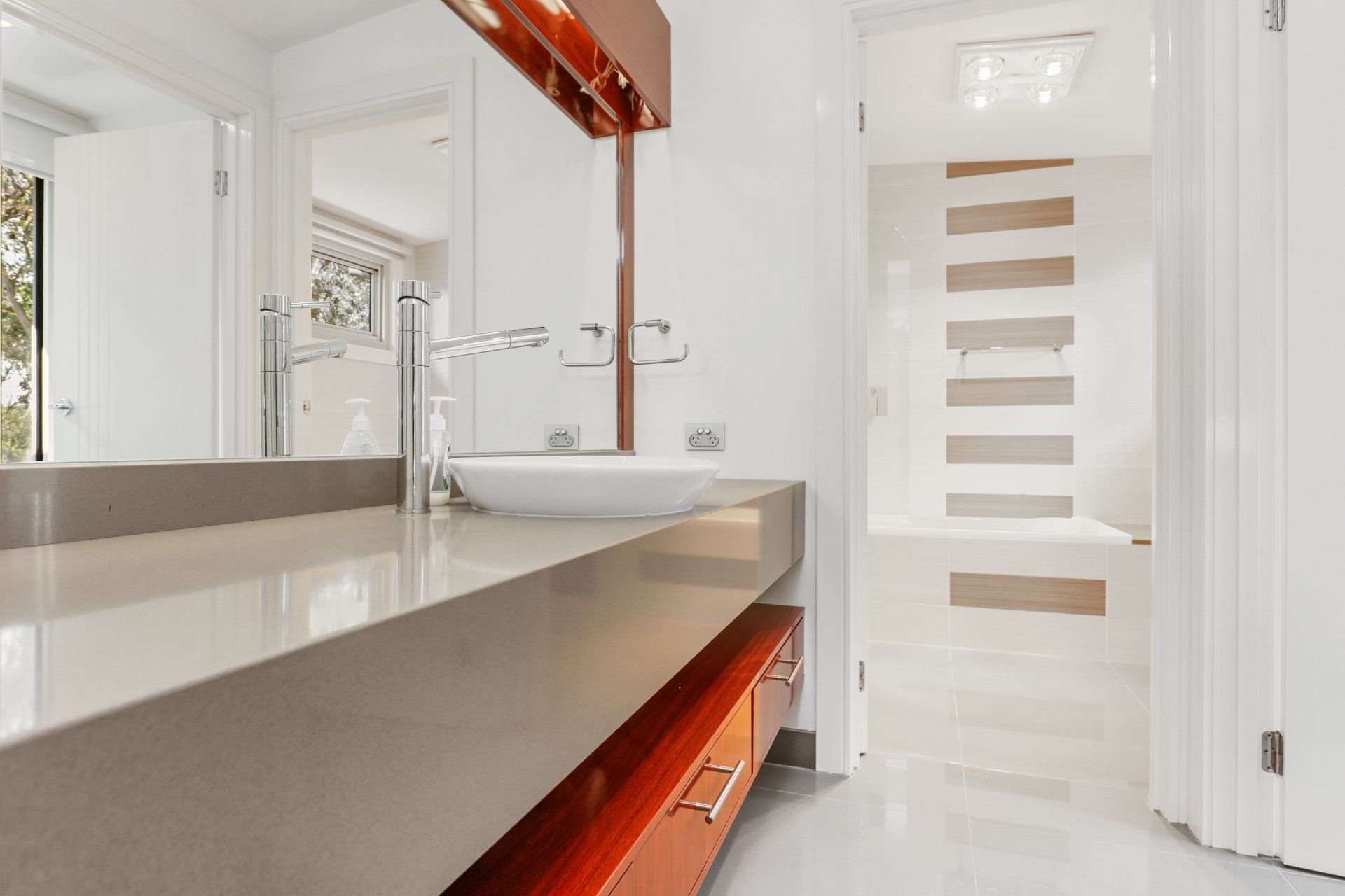 A bathroom with a sink and a large mirror