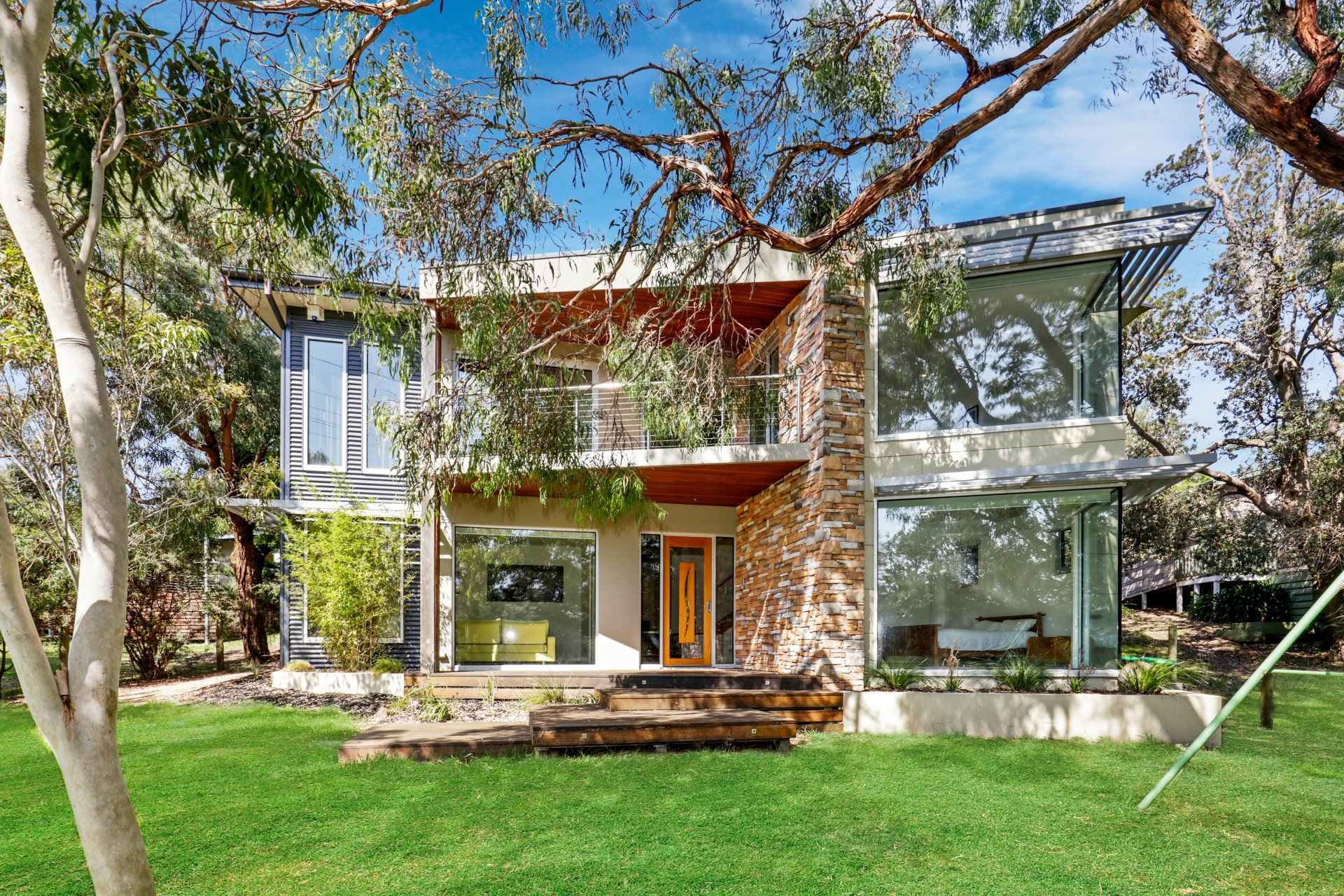A large house with a lot of windows is surrounded by trees
