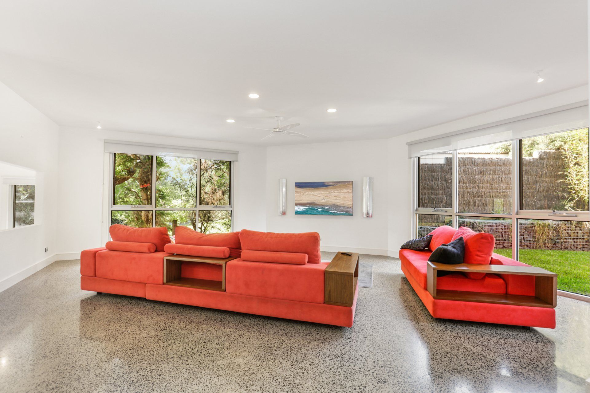 A living room with two red couches and a flat screen tv.