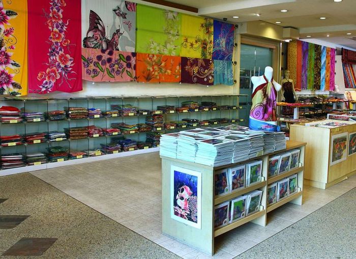 Boutique interior with colorful textiles, scarves, and prints for sale.