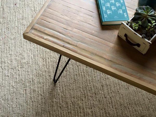 wooden table sits on light tan carpet