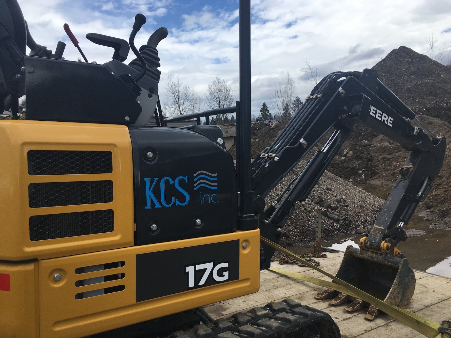 A yellow and black excavator with the number 17g on the side of it.