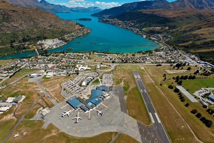 an aerial view of an airport with a lake in the background