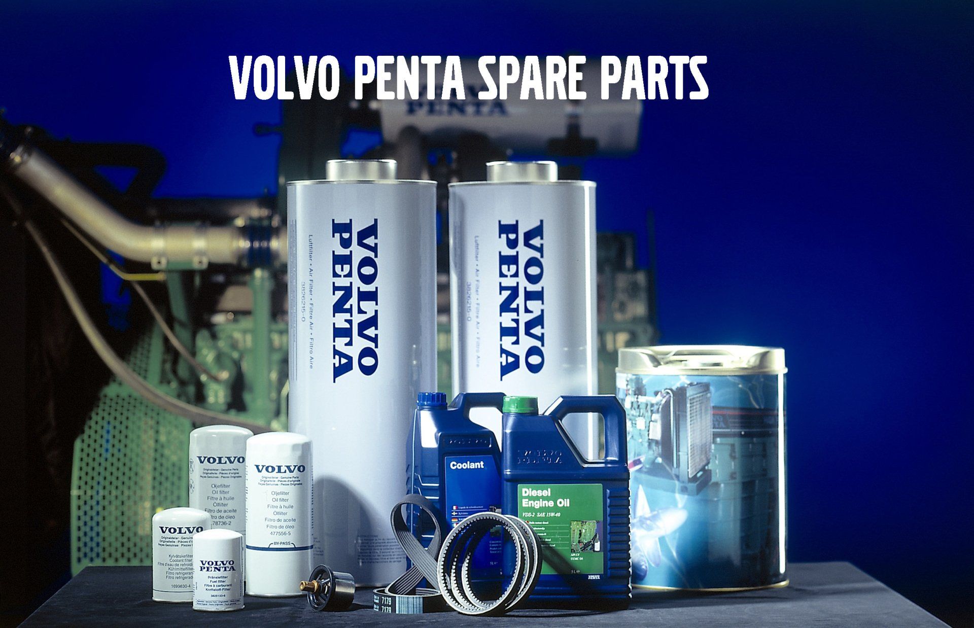 A collection of Volvo Penta spare parts, including bottles, filters, and cans, displayed on a table against a blue background.