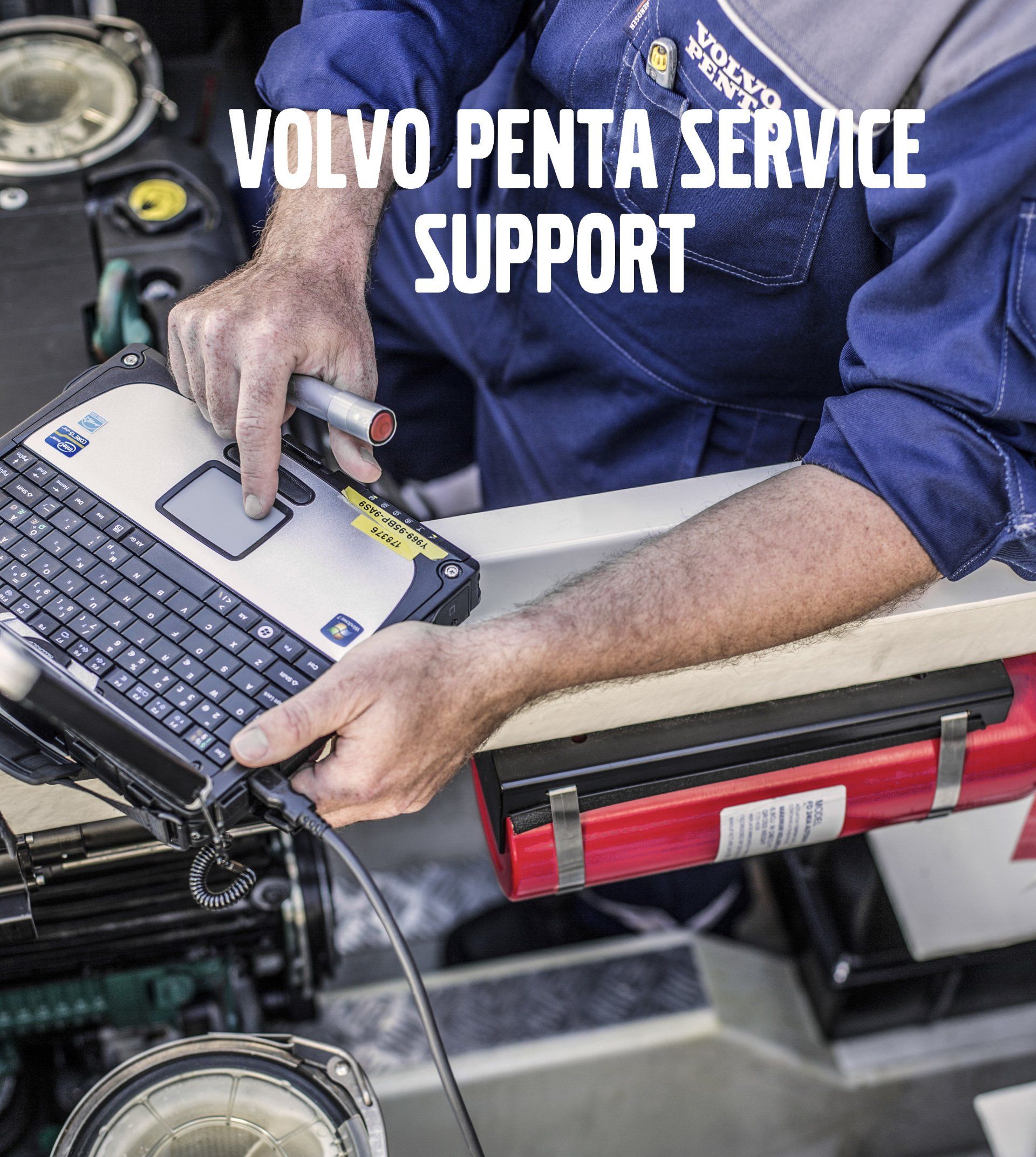 A mechanic in a blue work uniform uses a diagnostic laptop to service engine equipment, with text reading Volvo Penta.
