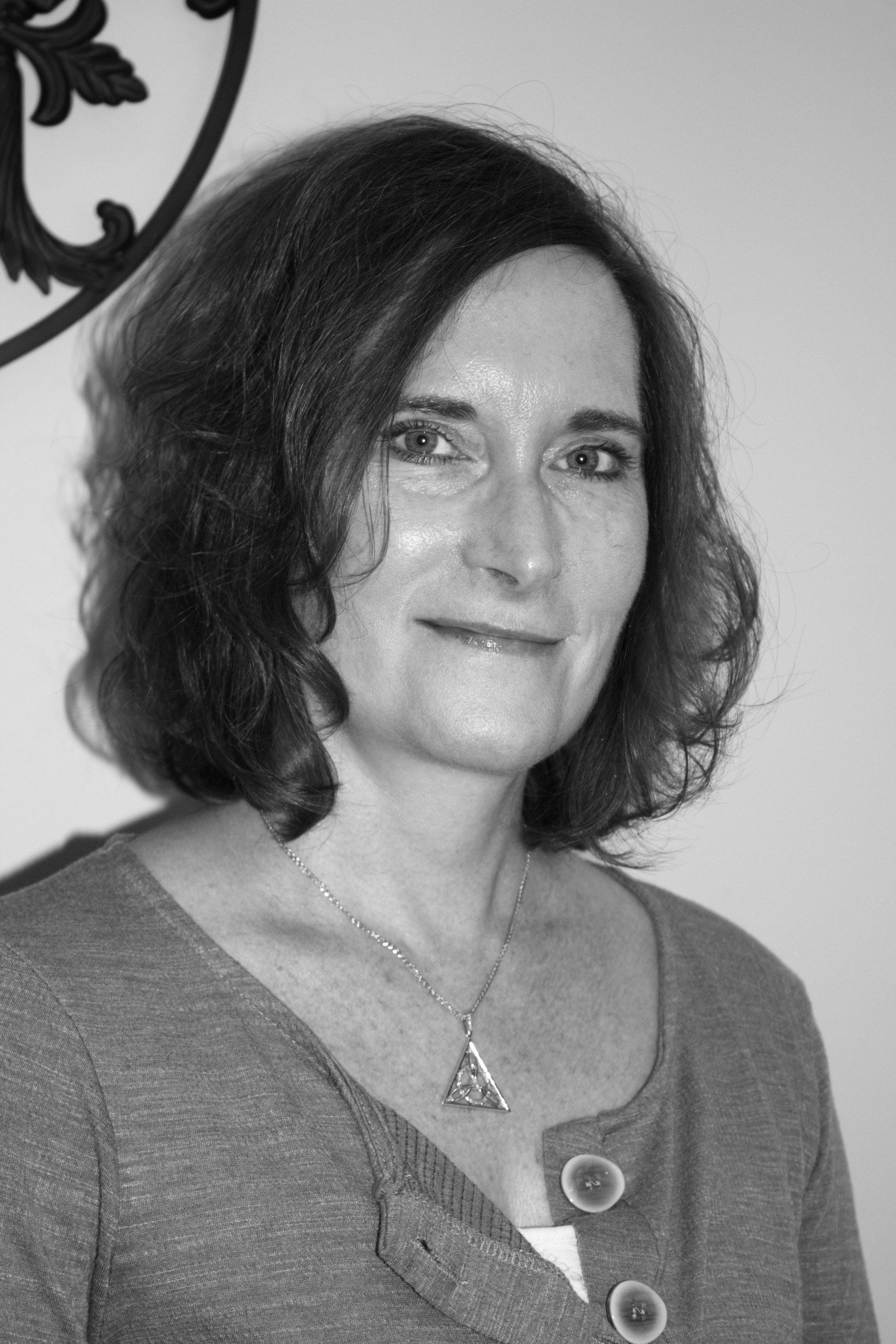 A black and white photo of a woman wearing a necklace.
