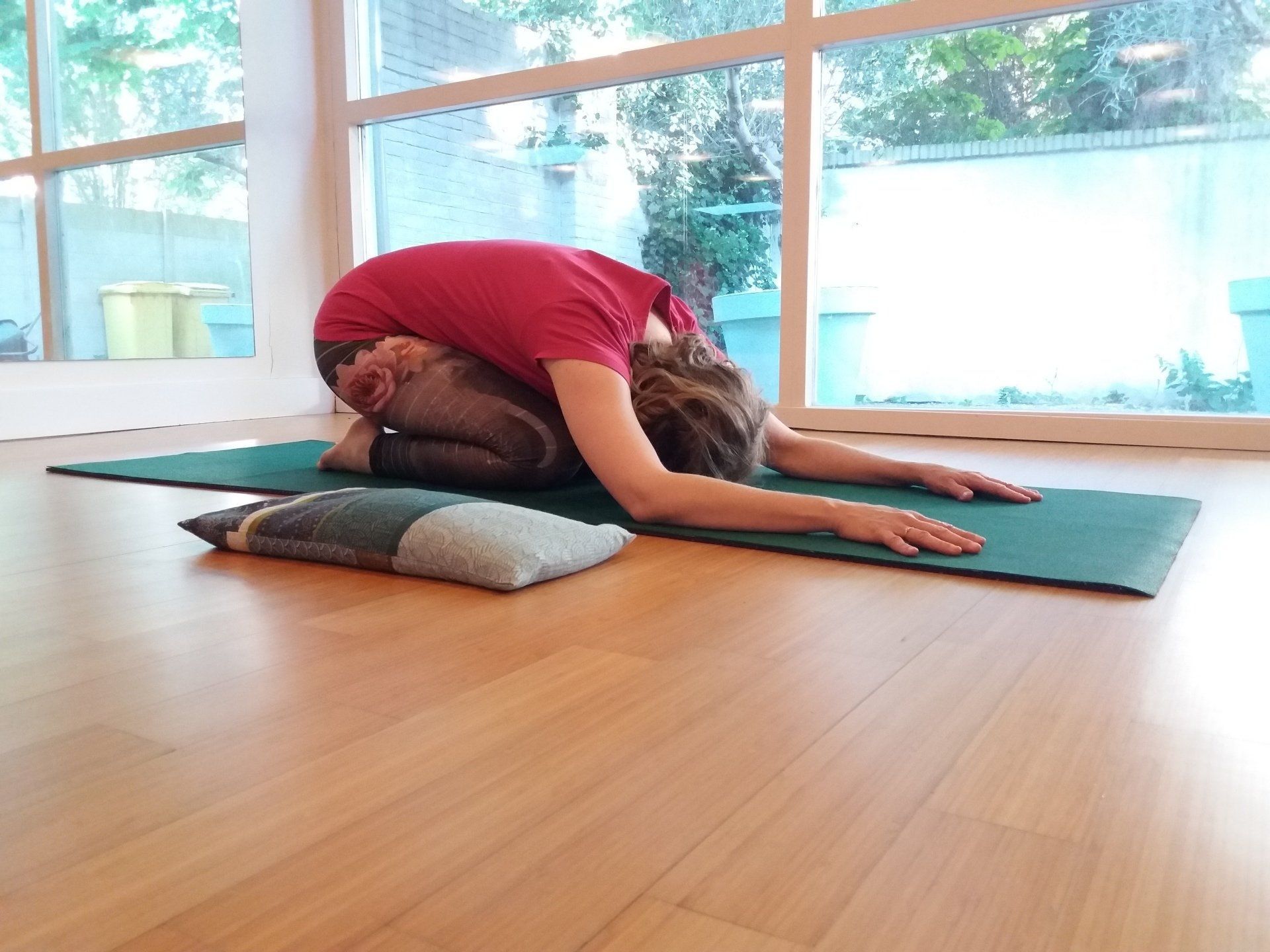 Yoga houding: kindhouding met billen op de hielen en armen uitgestrekt naar voren.